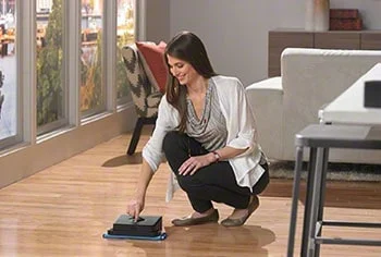 Woman starts the robot mop.